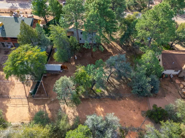 an aerial view of residential houses with outdoor space and trees