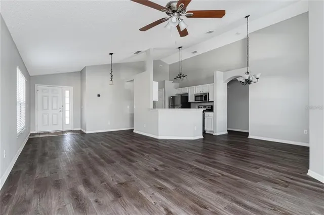 a view of a kitchen with wooden floor and a ceiling fan