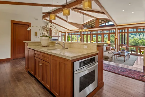 a kitchen with a stove a wooden floor and a dining table