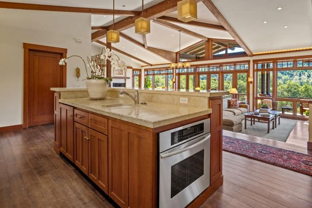 a kitchen with a stove a wooden floor and a dining table