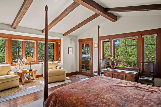 a bedroom with furniture and large windows