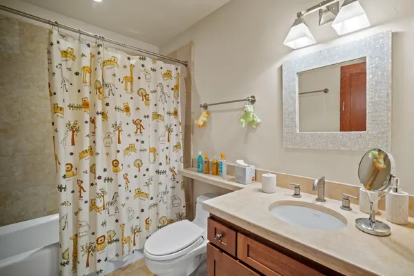a bathroom with a granite countertop sink a toilet and a mirror