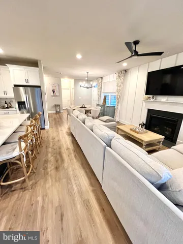 a living room with stainless steel appliances kitchen island granite countertop furniture a rug and a view of kitchen