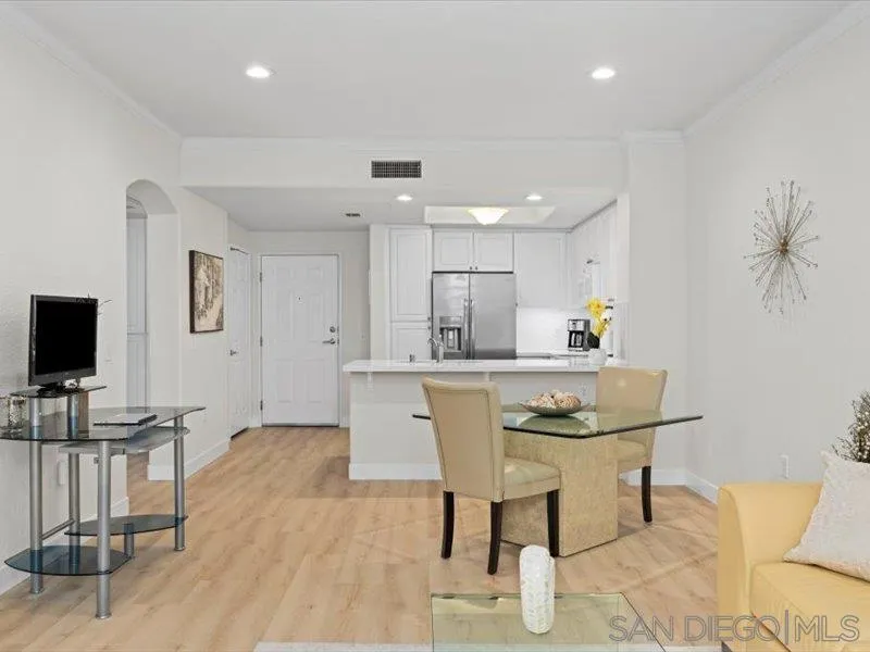 9237 Regents Road, Unit K101 La Jolla, CA 92037 - Photo 8 of 29 a kitchen with stainless steel appliances kitchen island granite countertop a table and chairs in it
