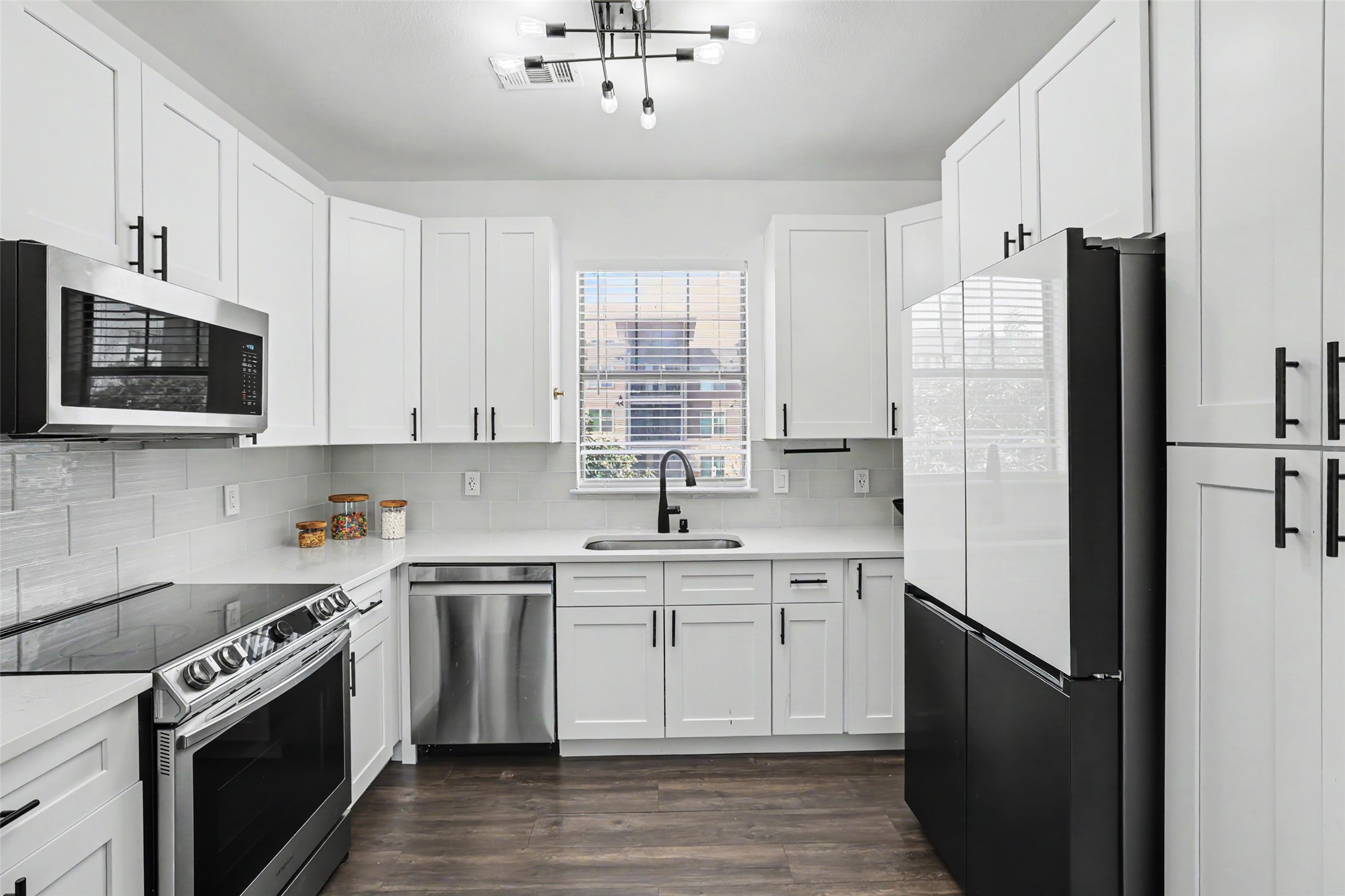 11203 Ranch Road 2222, Unit 2203 Austin, TX 78732 - Photo 2 of 38 A streamlined culinary space features modern white cabinetry and stainless steel appliances.