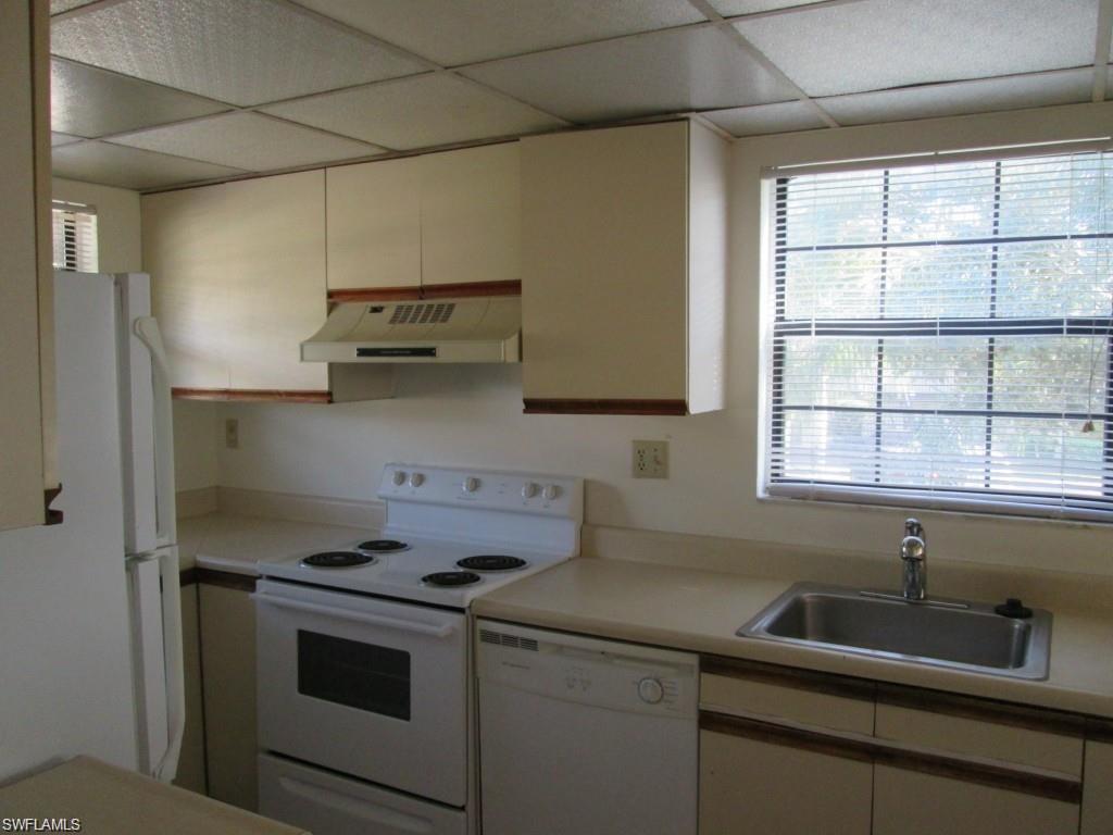 5355 Treetops Drive, Unit S201 Naples, FL 34113 - Photo 2 of 7 a kitchen with a sink stove and cabinets