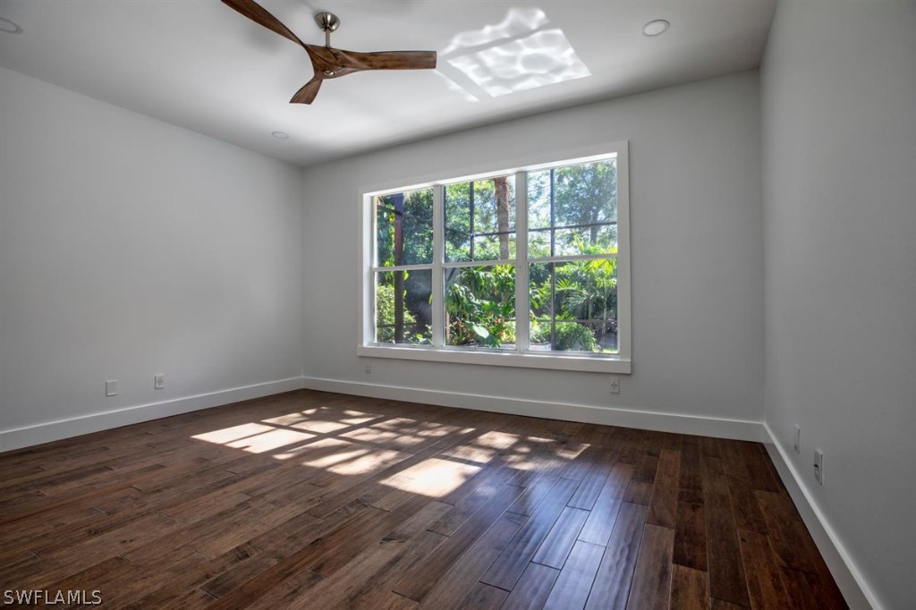 8856 Ventura Way Naples, FL 34109 - Photo 16 of 34 a view of an empty room with wooden floor and a window