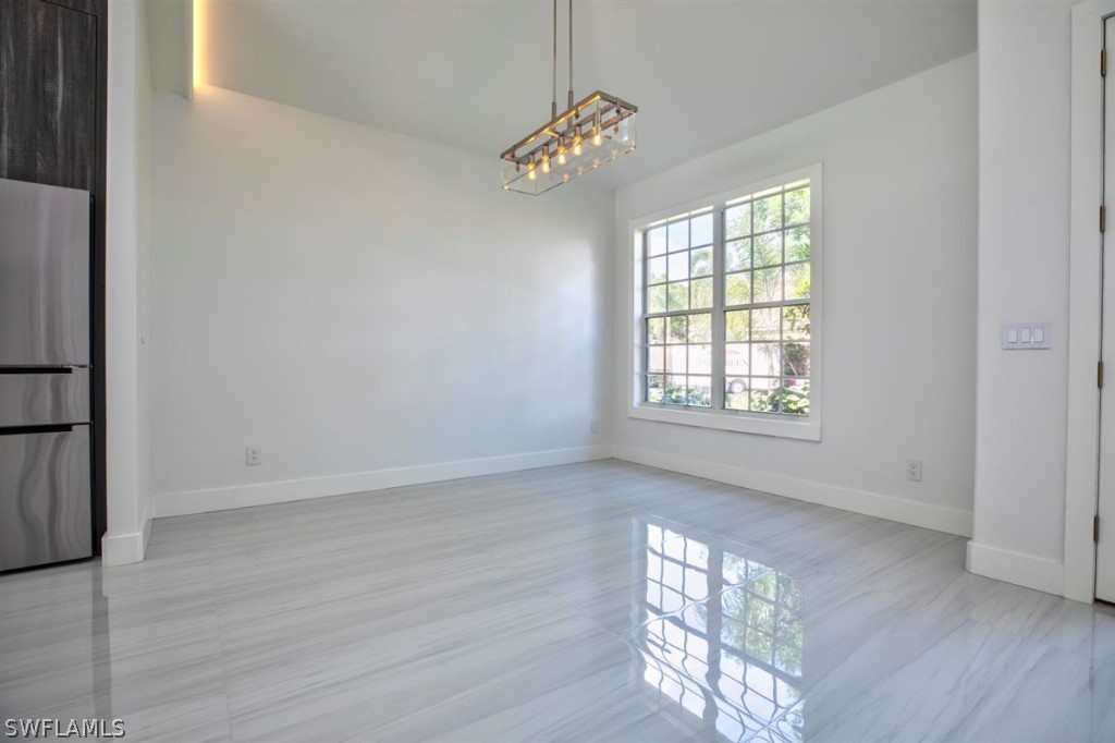 8856 Ventura Way Naples, FL 34109 - Photo 5 of 34 wooden floor in an empty room with a window