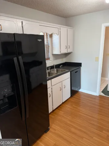a kitchen with granite countertop a sink a stove and cabinets
