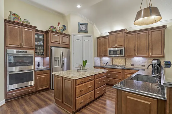a kitchen with stainless steel appliances granite countertop a stove and a refrigerator