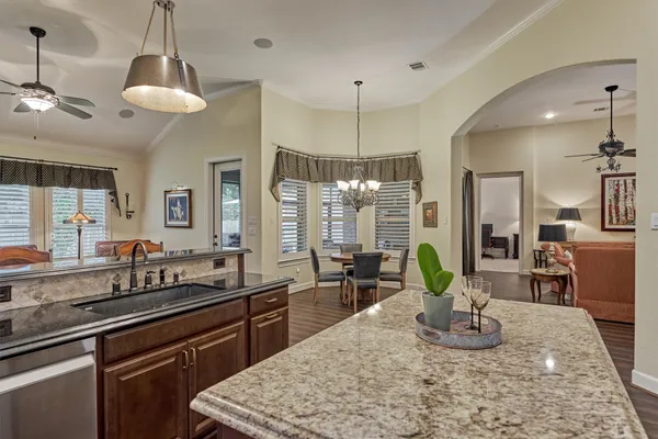 a kitchen with granite countertop a sink a counter top space cabinets and stainless steel appliances