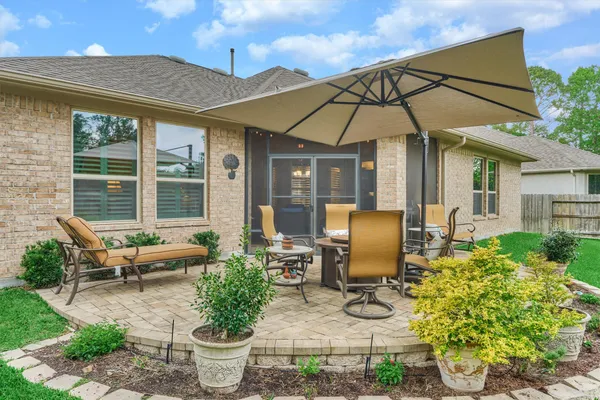 a view of a patio with table and chairs under an umbrella