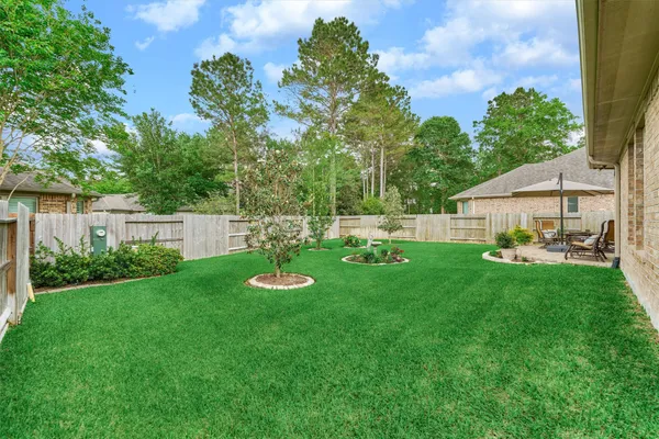 a view of a patio with table and chairs and potted plants with wooden floor and fence