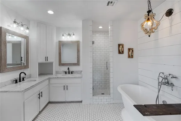 a bathroom with a double vanity sink mirror and bathtub