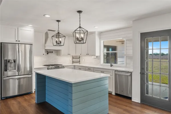 a kitchen with stainless steel appliances a stove a sink and a refrigerator