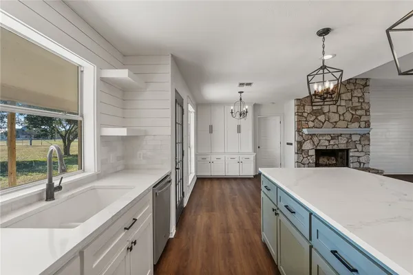 a kitchen with a sink a counter top space and stainless steel appliances