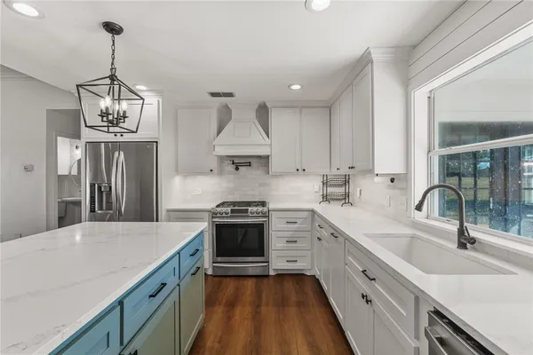 a kitchen with stainless steel appliances a sink stove and refrigerator