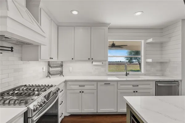 a kitchen with a sink stove and cabinets