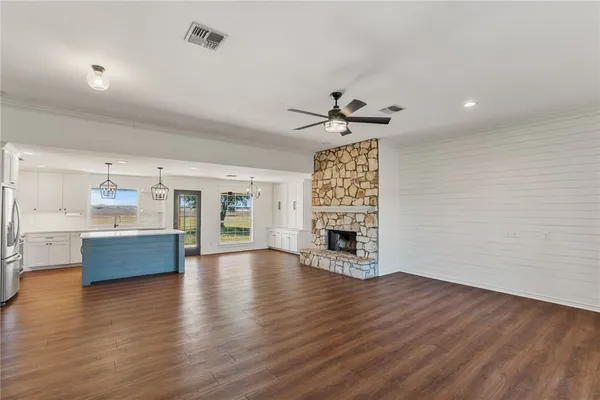 a view of an empty room with a fireplace and a window