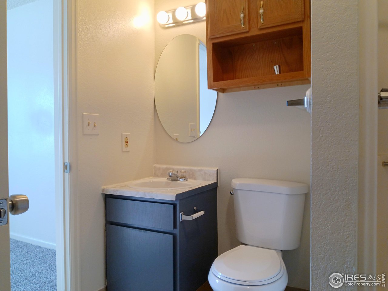 229 15th Street Greeley, CO 80631 - Photo 17 of 19 a bathroom with a toilet sink and mirror