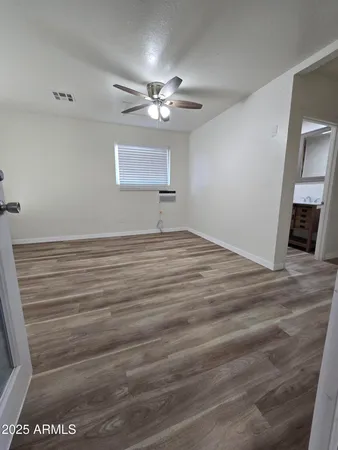 a view of empty room with wooden floor
