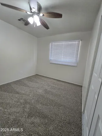en empty room with windows and fan