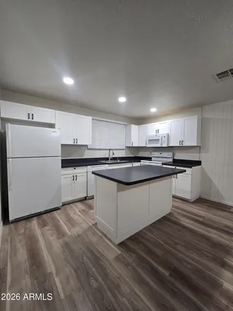 a large kitchen with stainless steel appliances granite countertop a stove a sink dishwasher and a refrigerator