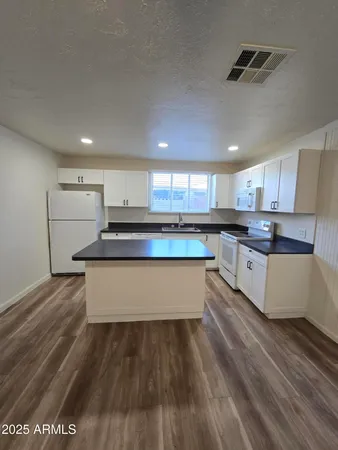 a large kitchen with kitchen island a stove a sink dishwasher and a oven with cabinets