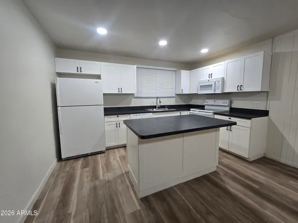 a kitchen with a sink a stove a refrigerator and white cabinets