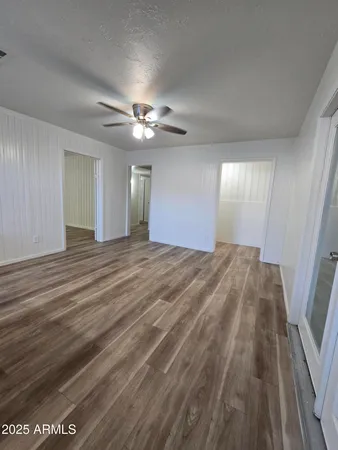 a view of an empty room and chandelier fan