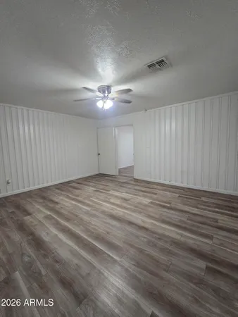 a view of an empty room with wooden floor