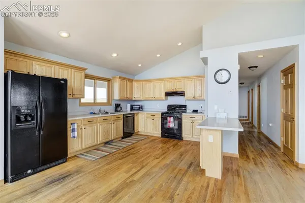 a kitchen with stainless steel appliances a refrigerator a stove top oven and a sink