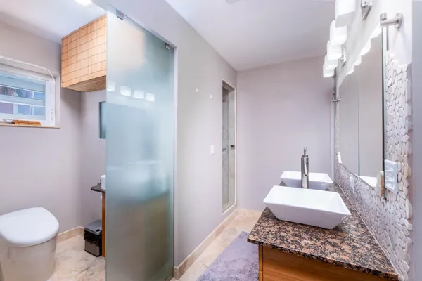 a living room with a black white checkered floor with a gaming machine and dining chair