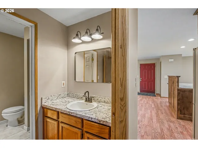 a bathroom with a granite countertop sink and a mirror