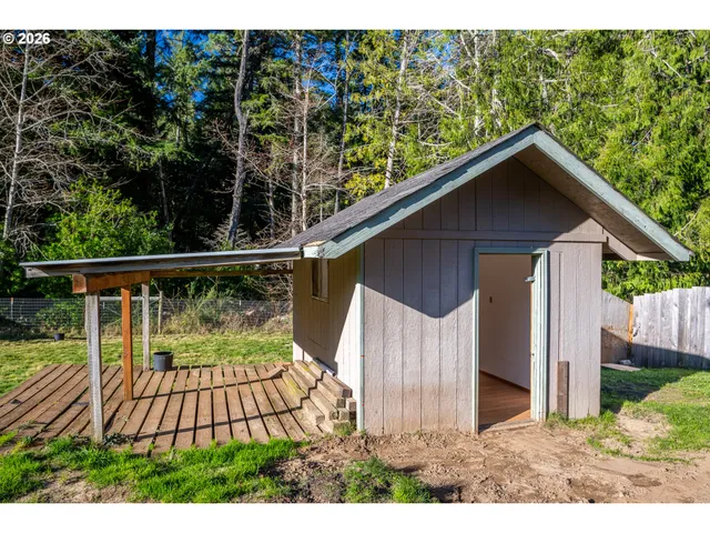 a view of a wooden house with a yard and plants