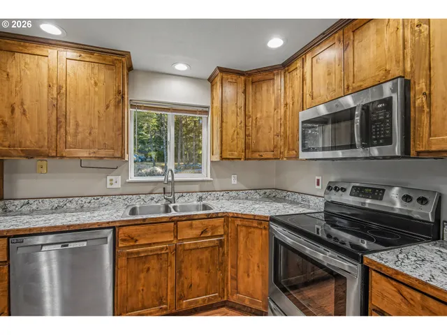 a kitchen with stainless steel appliances granite countertop a stove a sink dishwasher and a microwave