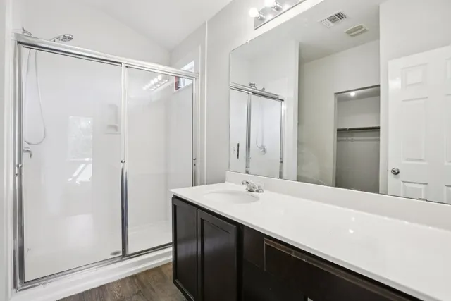a bathroom with a double vanity sink a mirror and shower