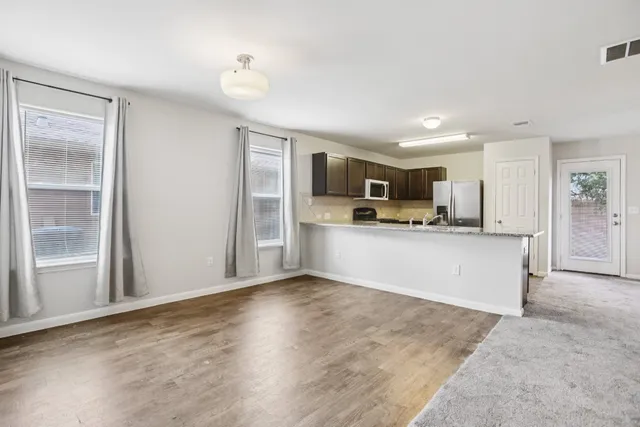 a view of kitchen with kitchen island a sink appliances and cabinets