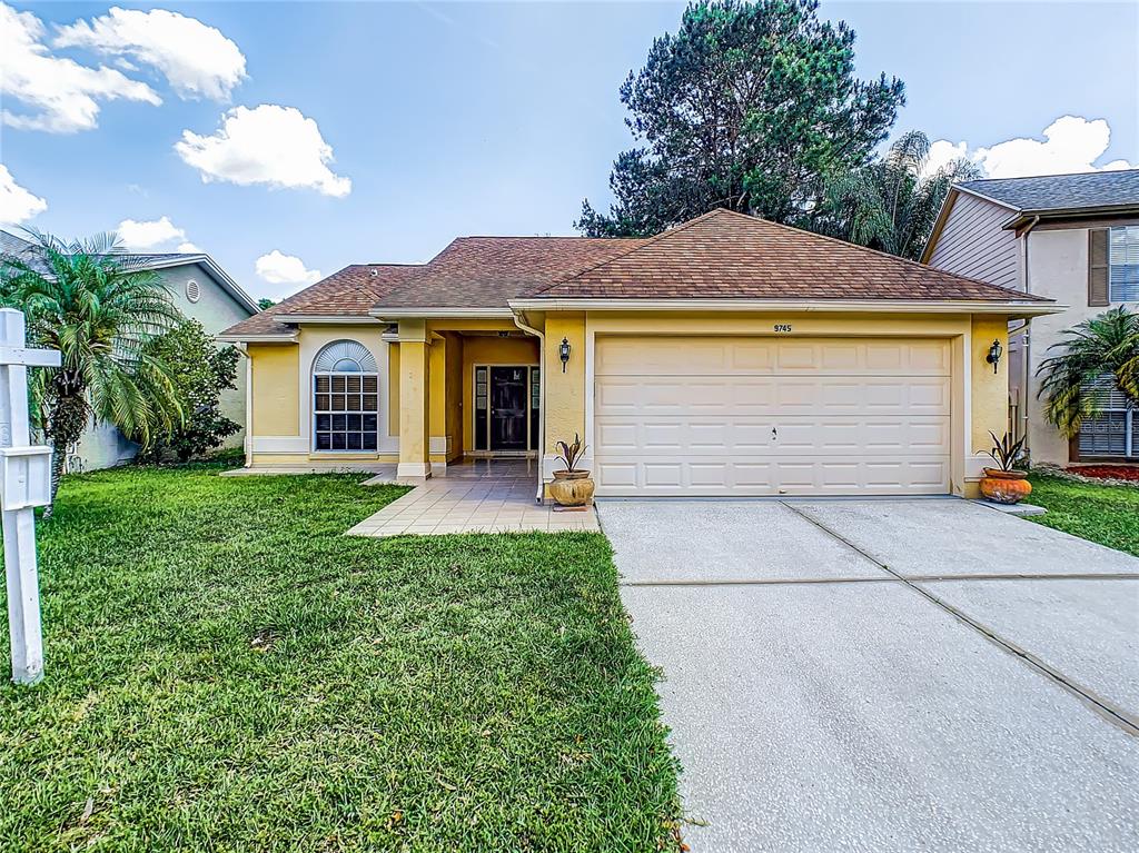 9745 Fox Hollow Road Tampa, FL 33647 - Photo 1 of 1 a front view of a house with a yard and garage