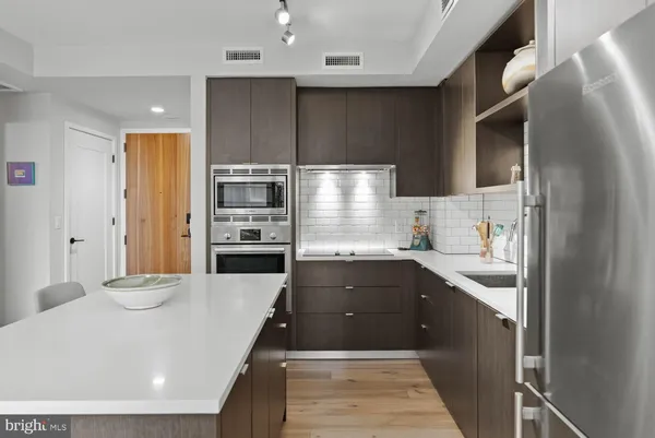 a kitchen with stainless steel appliances a refrigerator sink and cabinets