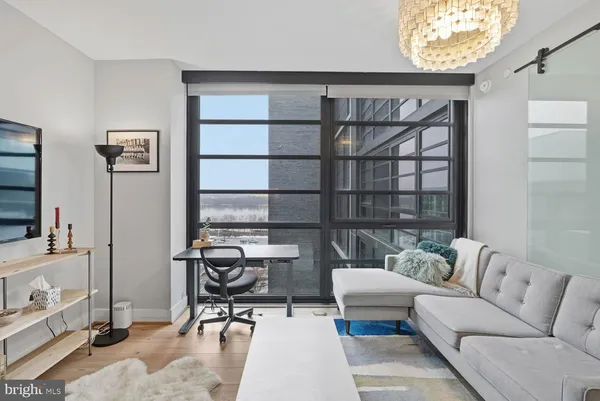 a living room with furniture a window and a flat screen tv