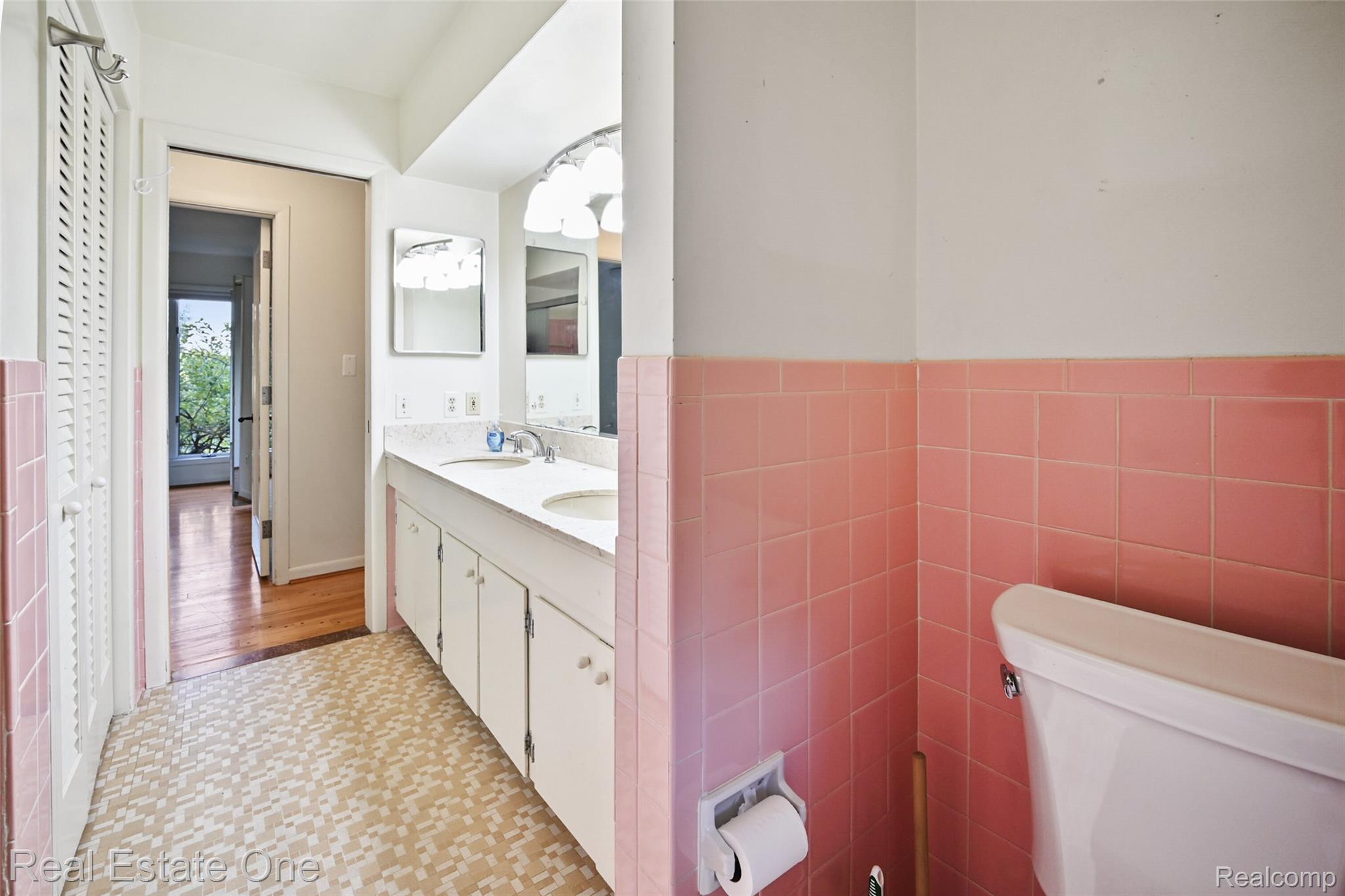 895 Rowe Road Milford, MI 48380 - Photo 42 of 50 Upper Level Bath. Dual vanity with integrated sinks, white cabinetry, and wall-mounted mirrors