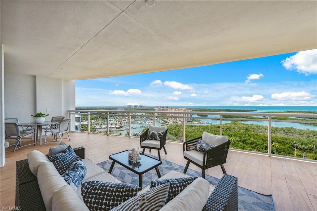 13915 Old Coast Road, Unit 1603 Naples, FL 34110 - Photo 11 of 37 a living room with furniture a rug and a floor to ceiling window