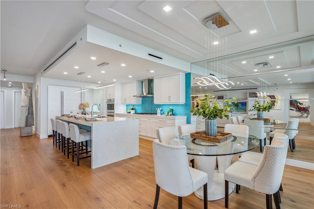 13915 Old Coast Road, Unit 1603 Naples, FL 34110 - Photo 5 of 37 a kitchen with a dining table chairs and wooden floor
