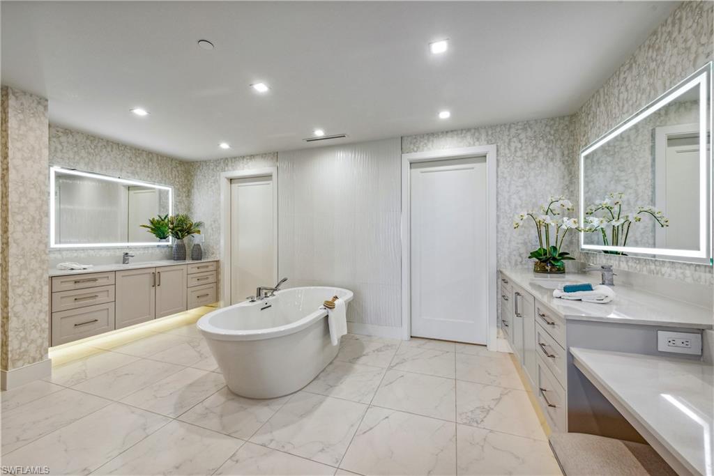 13915 Old Coast Road, Unit 1603 Naples, FL 34110 - Photo 6 of 37 a large bathroom with a double vanity sink a mirror and a bathtub