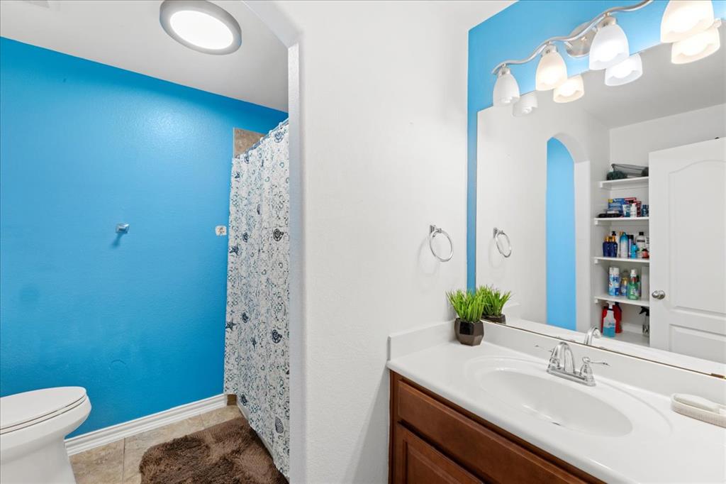 349 Razzmatazz Trail Buda, TX 78610 - Photo 8 of 27 A well-lit bathroom with a bright blue accent wall offers a crisp, inviting atmosphere.