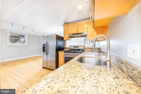 a kitchen with granite countertop a refrigerator and a sink