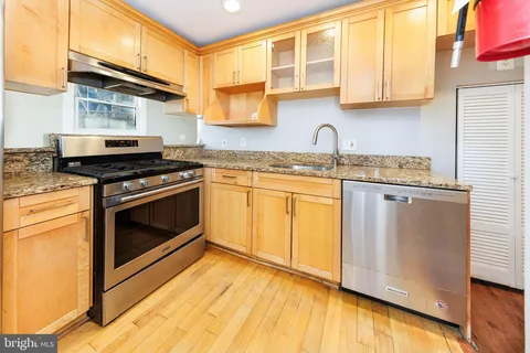 a kitchen with granite countertop wooden cabinets stainless steel appliances and a counter space