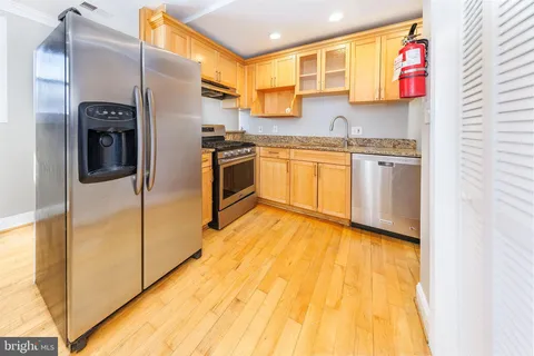 a kitchen with stainless steel appliances granite countertop a stove a sink and a refrigerator