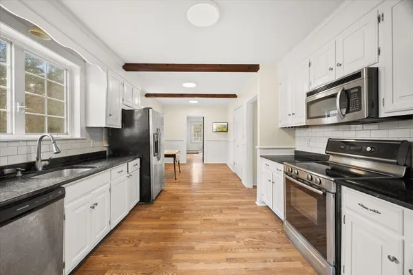 a large kitchen with stainless steel appliances a stove a sink dishwasher a microwave oven and a refrigerator